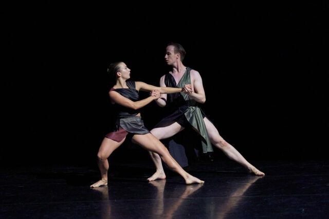 Contemporary Dance Performance with Two Dancers in Dynamic Pose on Dark Stage