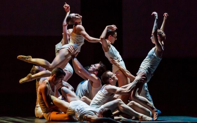 Contemporary dance group performance artistic pose on stage with dynamic lighting