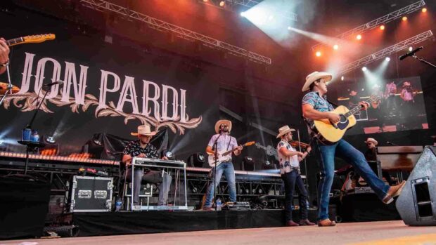 A country music band plays on stage with guitars and violin during a lively concert, HD Desktop Wallpaper