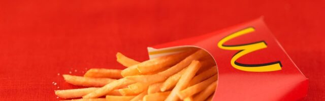 Crispy McDonalds French Fries in Signature Red Packaging on Red Background Wallpaper