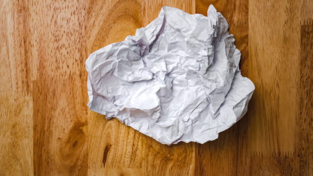 Crumpled White Paper on Wooden Surface Wallpaper
