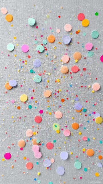 Cute background pastel colors, colorful confetti on a light grey canvas for a cheerful design.