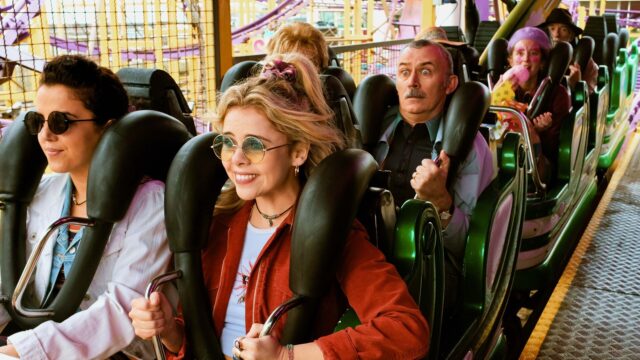 Derry Girls TV Series Characters Riding Roller Coaster Amusement Park Scene Wallpaper
