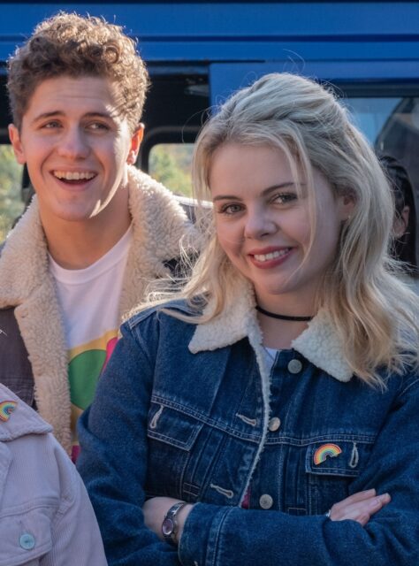 Derry Girls TV Series Characters Smiling in Casual Winter Jackets Wallpaper