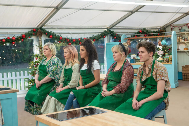 Derry Girls TV Series Contestants Wearing Green Aprons in Festive Kitchen Wallpaper
