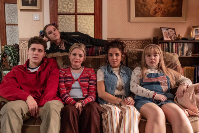 Derry Girls TV Series Group Sitting on Vintage Sofa Wallpaper