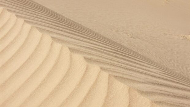 The image shows detailed sand dune patterns in Algeria, capturing the natural texture of the desert landscape, HD Desktop Wallpaper
