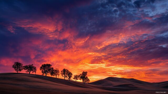 Desktop Image Wallpaper High Quality, A Dramatic Sunset Over Rolling Hills With Silhouetted Trees Against The Colorful Sky