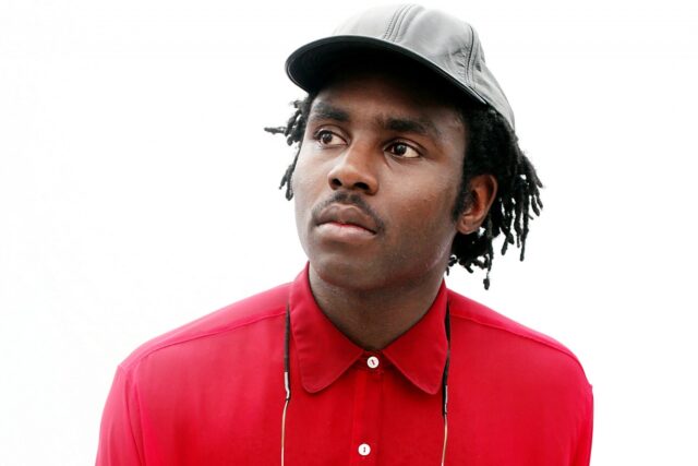Dev Hynes Vibrant Portrait Wallpaper In Red Shirt And Cap