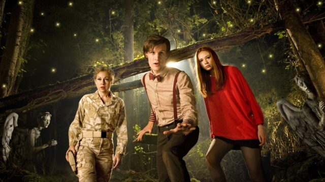This image shows Doctor Who Matt Smith and his companions exploring a mysterious forest with glowing lights, 2K Desktop Wallpaper