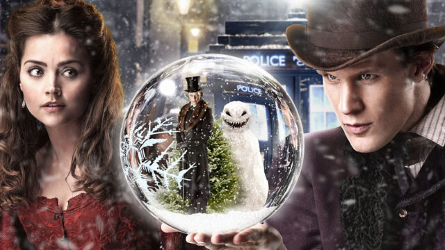 A man holding a snow globe with a snowy scene inside including a Christmas tree and a figure in a top hat, HD Desktop Wallpaper