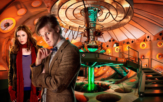 The Doctor played by Matt Smith stands thoughtfully in the orange lit control room of the TARDIS with a companion, HD Desktop Wallpaper