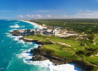 The image shows a beautiful coastal area with waves crashing on rocky shores and green golf course land, featuring Dominica wallpapers, HD Desktop Wallpaper