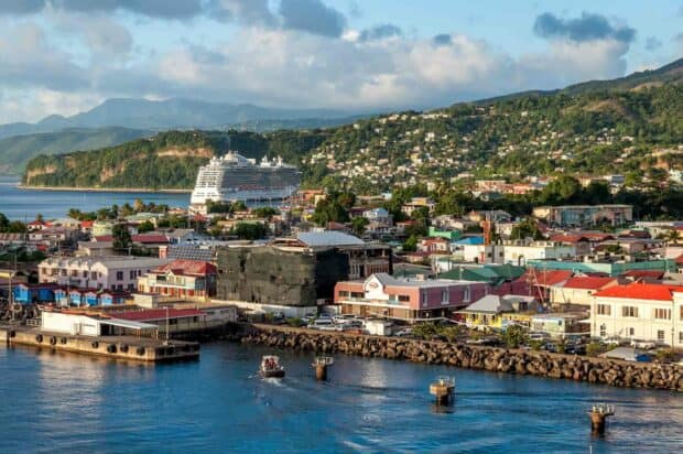 A cruise ship docks near the colorful coastal town of Dominica surrounded by hills and blue waters, HD Desktop Wallpaper