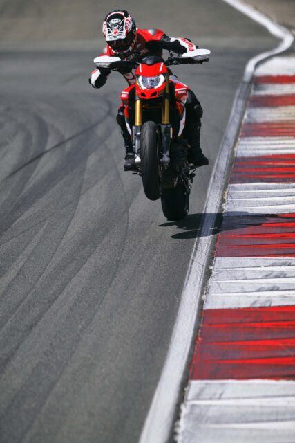 Ducati Hypermotard 950 Motorcycle Performing Wheelie on Race Track Wallpaper