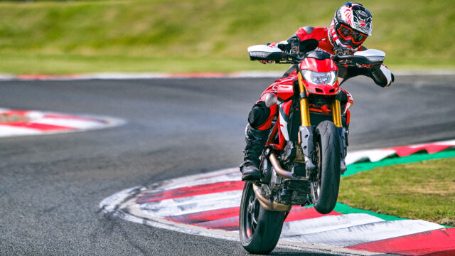 Ducati Hypermotard 950 Racing on Track Wheelie Action Wallpaper