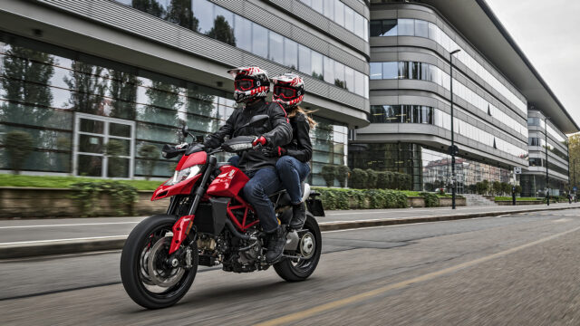 Ducati Hypermotard 950 Riding Through Urban Streets with Two Riders in Full Gear Wallpapers