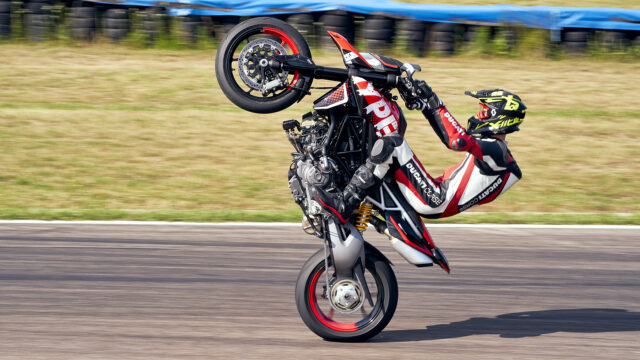 Ducati Hypermotard 950 Stunt Rider Performing Wheelie on Race Track Wallpaper