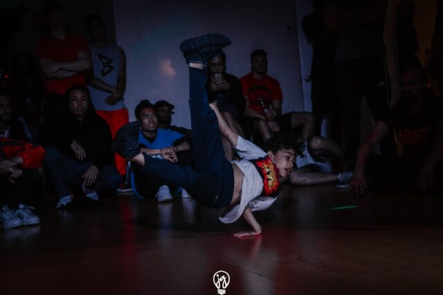 Dynamic Breakdancing Move Captured In Action Wallpaper