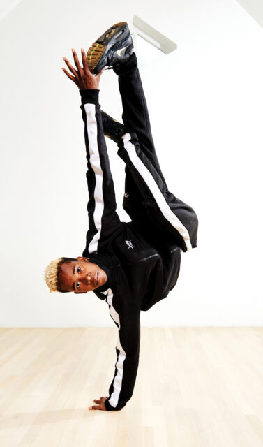 Dynamic Breakdancing Pose On Wooden Floor Background