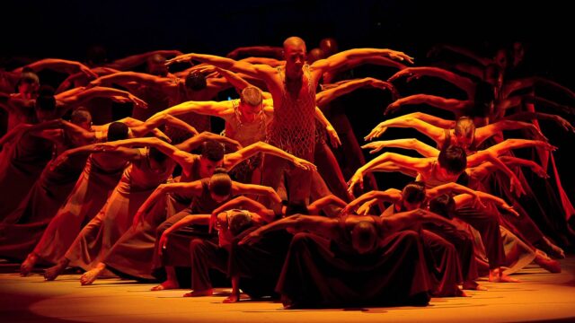 Dynamic Contemporary Dance Group Performance Wallpaper in Warm Lighting