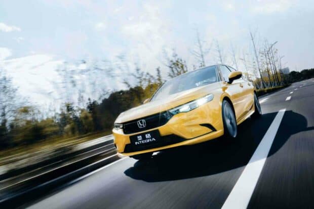 A yellow Honda Integra is driving fast on a clear road surrounded by blurred trees, HD Desktop Wallpaper