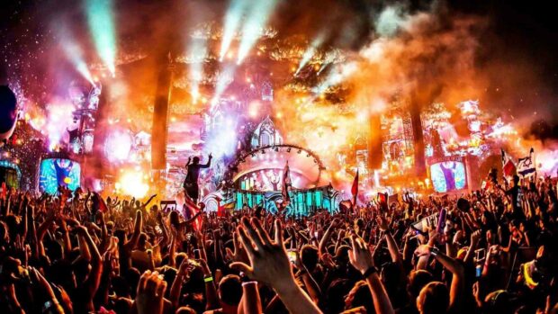 A large crowd is gathered at a concert enjoying the live music with colorful lights and smoke effects, HD Desktop Wallpaper