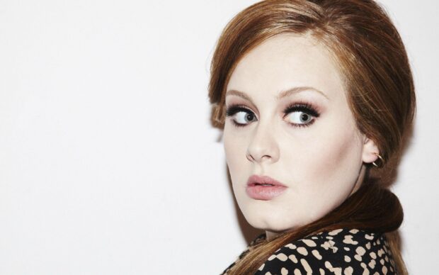 Adele Wallpapers of a woman with red hair and dramatic eye makeup posing against a plain white background, 2K Desktop Wallpaper