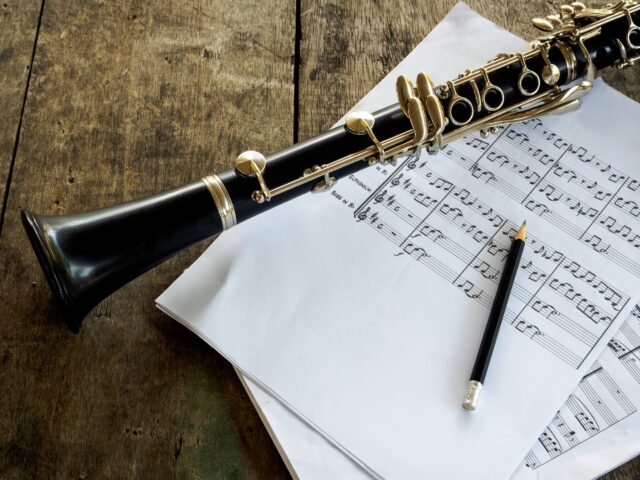 Elegant Clarinet And Sheet Music On Rustic Wooden Surface