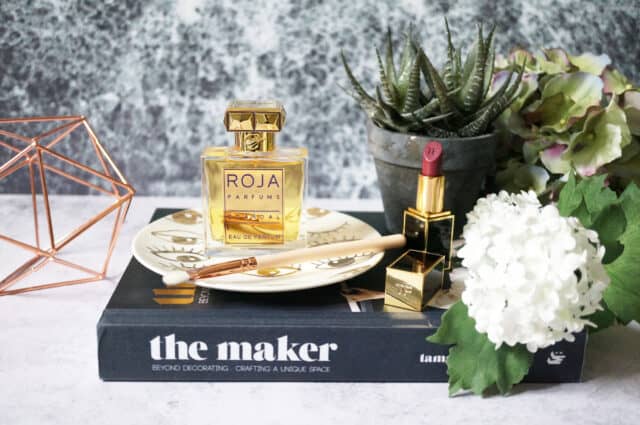 Elegant Roja Dove Perfume And Lipstick Display With Flowers