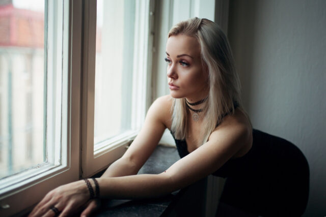 Elegant blonde woman wearing black choker necklace looking thoughtfully out window Choker wallpapers
