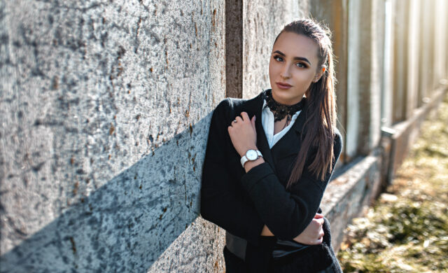 Elegant woman wearing black lace choker standing outdoors against stone wall Choker Wallpapers