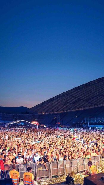 A large crowd enjoying a concert with excitement during sunset, HD Mobile Wallpaper
