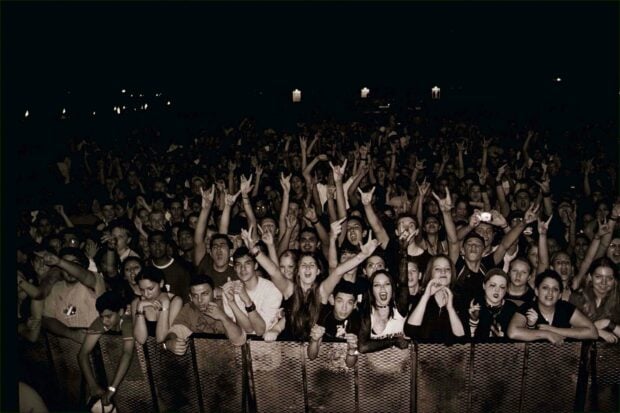 A large concert crowd is cheering and raising their hands during an event, 2K Desktop Wallpaper