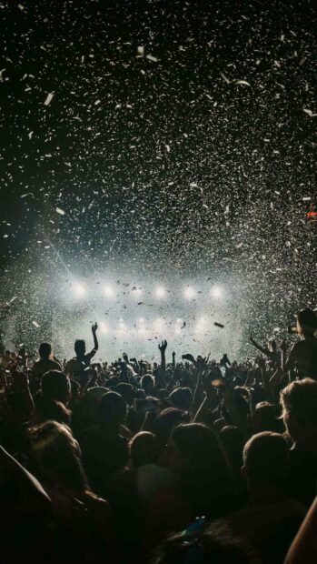 A large crowd enjoying a live concert with confetti falling under bright stage lights, 2K Phone Wallpaper