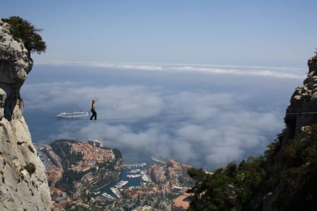 Extreme highline slacklining above a city with ocean view scenic wallpaper
