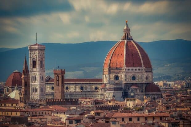 The cathedral dome and tower are set against a cloudy sky and mountain landscape, HD Desktop Wallpaper