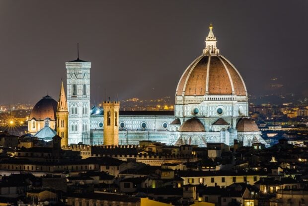 A famous cathedral illuminated at night with a clear city skyline behind it, HD Desktop Wallpaper