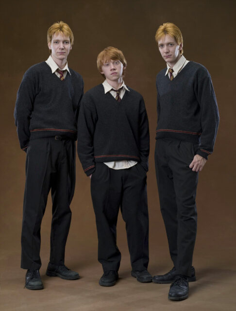 Fred And George Weasley With Sibling In Hogwarts Attire Wallpaper