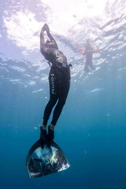 A freediver is ascending toward the surface using a monofin with an underwater view, HD Mobile Wallpaper