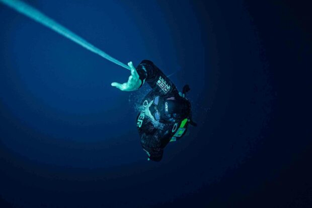 A freediver is descending into the deep ocean while holding onto a guide rope, Freediving Wallpapers, 2K Desktop Wallpaper
