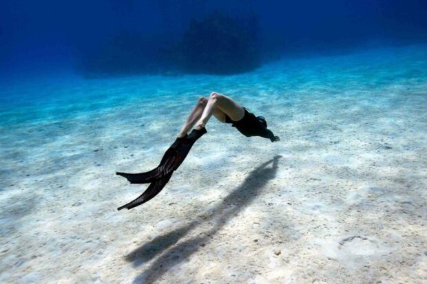A freediver explores the sandy ocean floor wearing long fins, showcasing freediving, HD Desktop Wallpaper