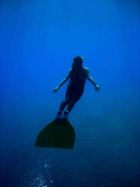 A freediver swims gracefully in the deep blue ocean, 2K Mobile Wallpaper