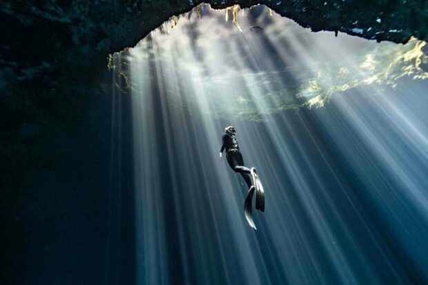 A freediver explores the depths of an underwater cave with sunlight streaming through the water, Freediving Wallpapers, HD Desktop Wallpaper