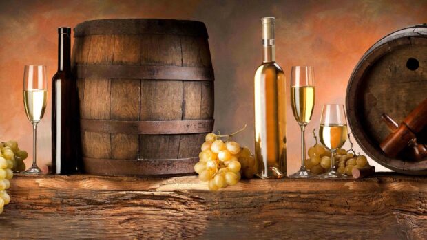 A rustic scene with fresh white grapes, wine bottles, glasses, and wooden barrels on a wooden surface, 4K Desktop Wallpaper