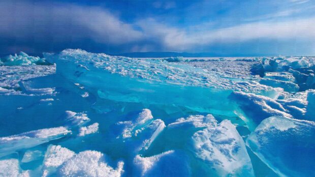 The Arctic landscape shows vast frozen ice sheets under a cloudy sky with shades of blue, 4K Desktop Wallpaper