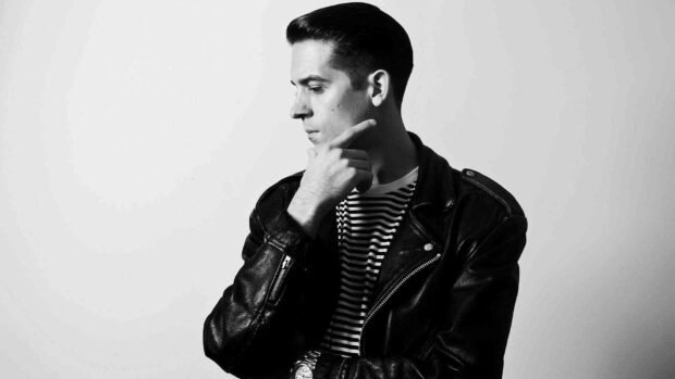 G Eazy is shown in a thoughtful pose wearing a black leather jacket and striped shirt, HD Desktop Wallpaper