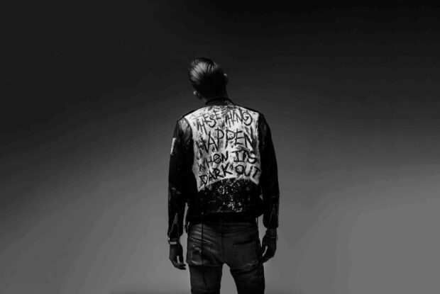 A black and white image of G Eazy standing with his back turned wearing a jacket with a painted message, HD Desktop Wallpaper