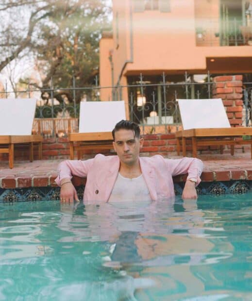 G Eazy is sitting calmly in a swimming pool wearing a pink jacket and white top, HD Mobile Wallpaper