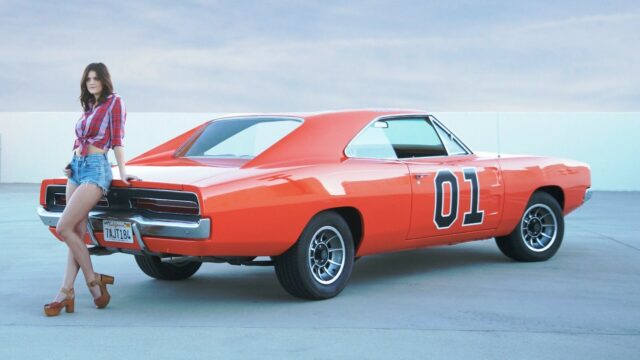 General Lee Car Wallpaper with Woman Standing Next to Classic Orange Muscle Car